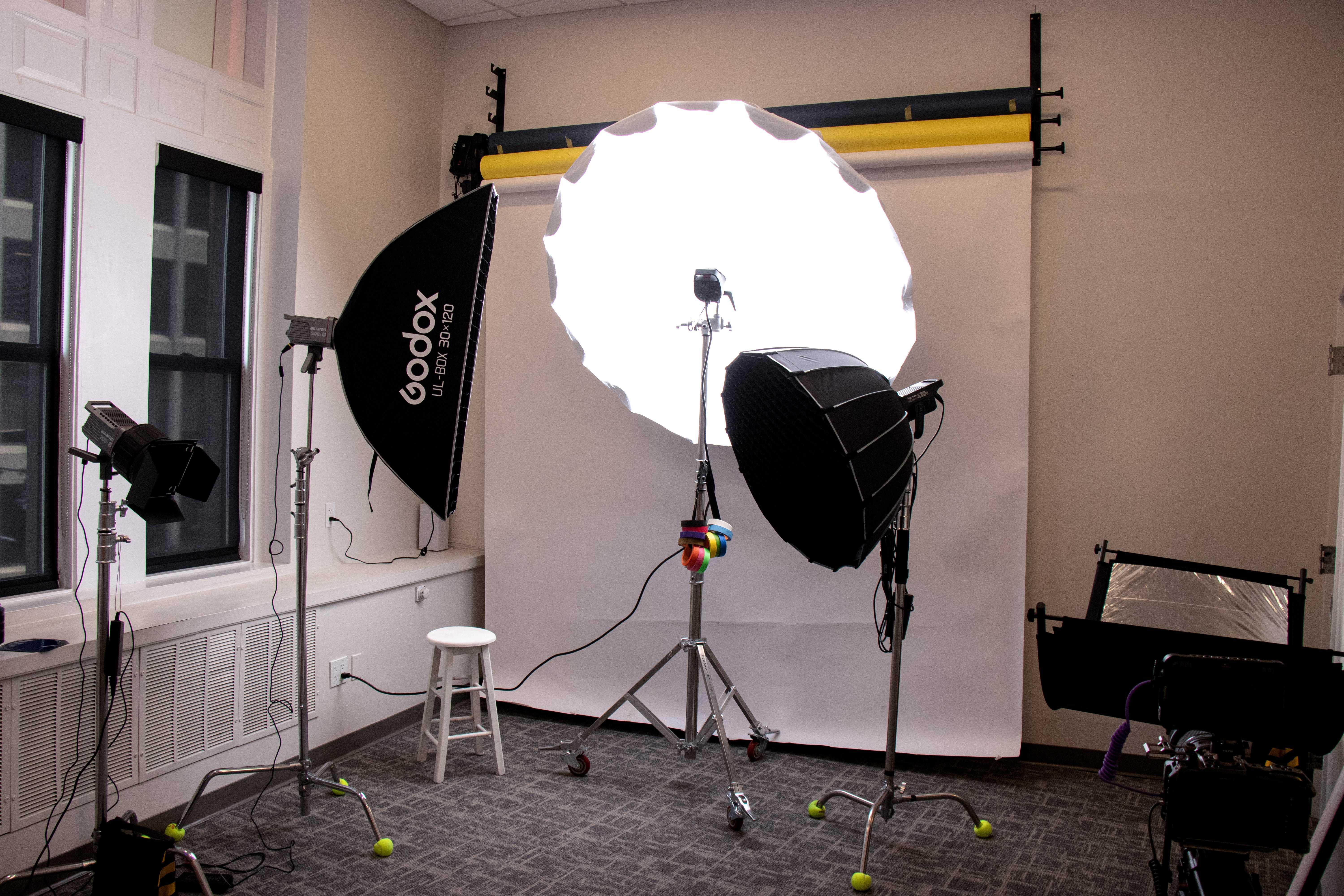 Large glowing parabolic light illuminating a white backdrop in the photography studio